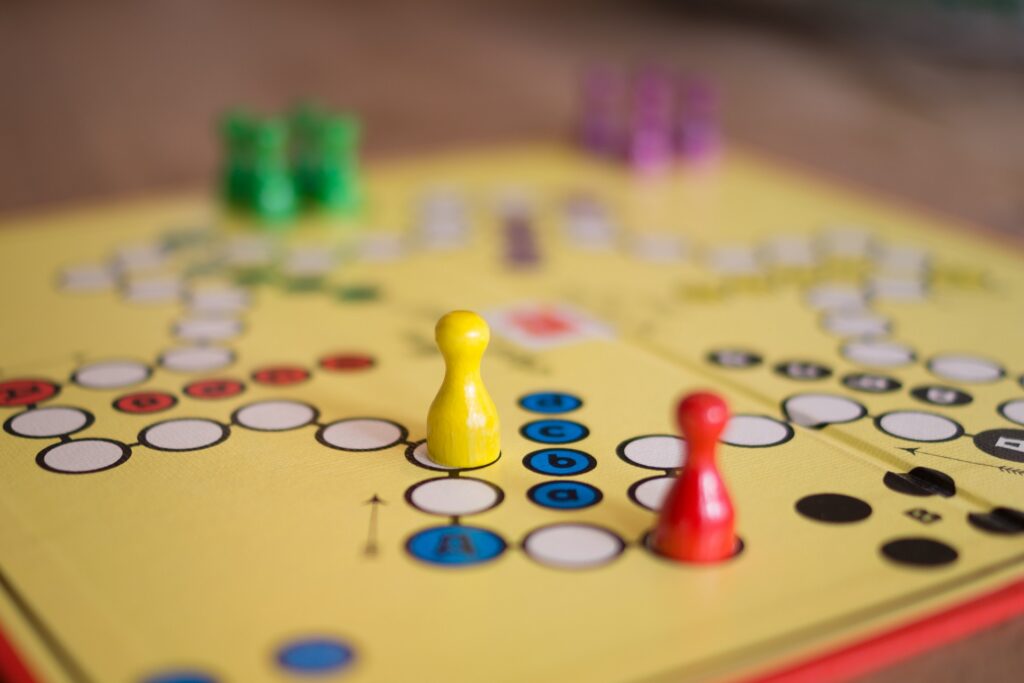 Pions colorés sur un plateau de jeu pédagogique utilisé pour illustrer la ludopédagogie en formation.