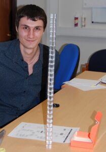 Participant en formation présentant une tour de cubes lors d’une activité pédagogique sur l’atteinte des objectifs.